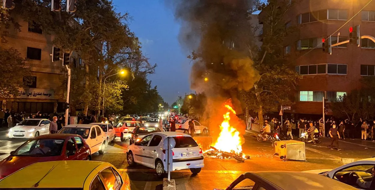 Горящий полицейский мотоцикл во время протестов в Тегеране / Reuters
