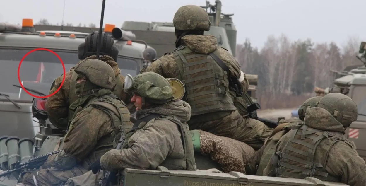 Беларускі сцяжок за шклом машыны з расійскімі вайскоўцамі
