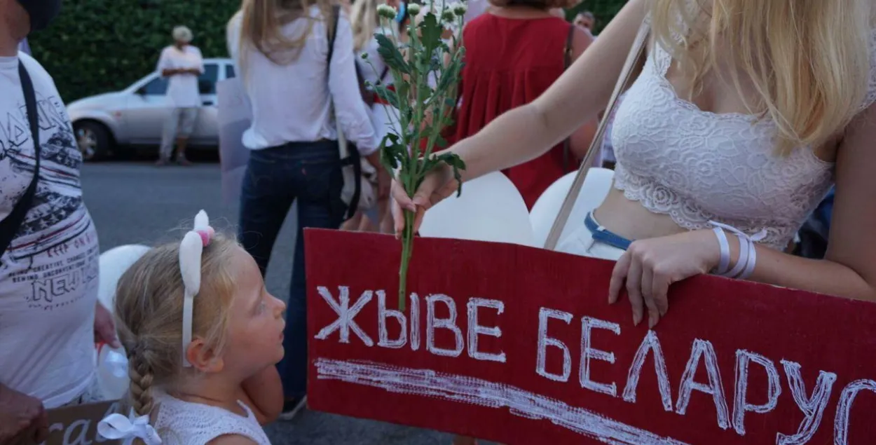 Дзяўчынка і плакат "Жыве Беларусь!" / Еўрарадыё