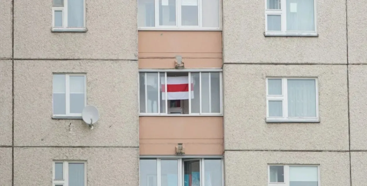 Бело-красно-белый флаг в окне (иллюстративное фото)
