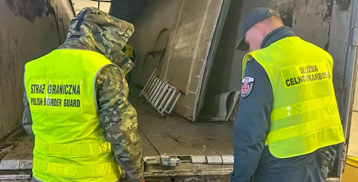 Памежнік і мытнік аглядаюць схованку ў падлозе фуры
