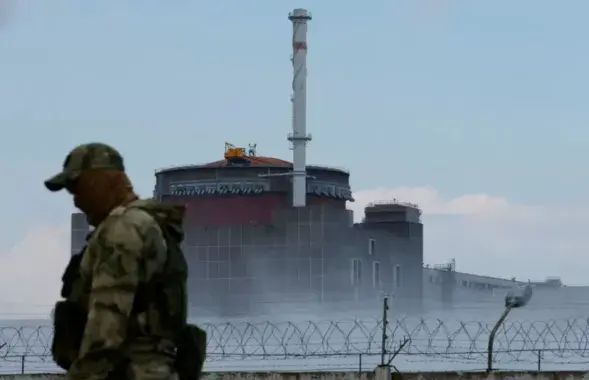 Военный на фоне ЗАЭС / Reuters
