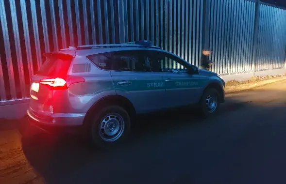 Автомобиль польской погранслужбы на фоне забора на границе с Беларусью
