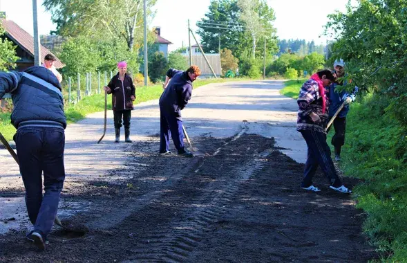 Жыхары вёскі самі робяць ямачны рамонт. Дарожнікі бясплатна забяспечылі іх матэрыяламі і тэхнікай.