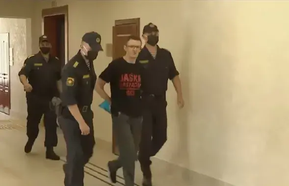 Дениса Ивашина ведут в суд / Скриншот с видео "Беларусь 1"​