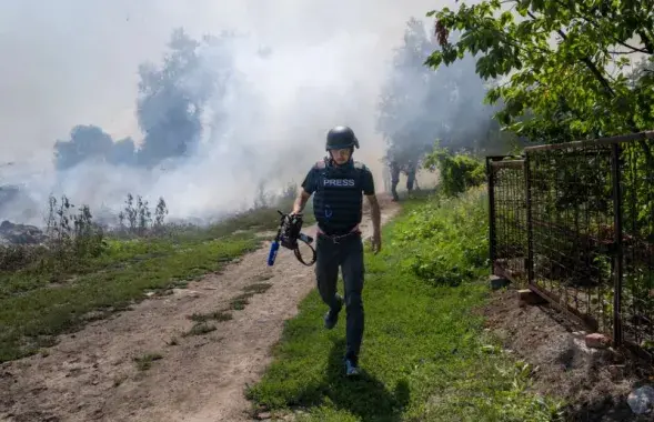 Дым после бомбардировки в Бахмуте за спиной журналиста / Bulent Kilic,&nbsp;AFP
