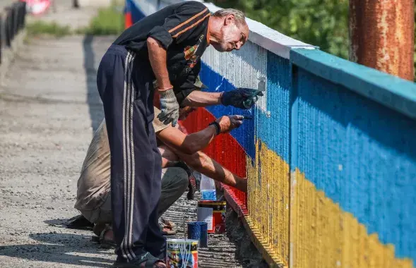 Мужчины перекрашивают мост в Украине / ura.ru
