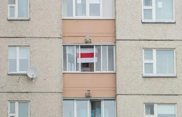 Бело-красно-белый флаг в окне (иллюстративное фото)
