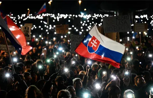Людзі запальваюць экраны тэлефонаў у Браціславе, Славакія, калі тысячы збіраюцца пратэставаць супраць палітыкі прэм'ер-міністра Роберта Фіца
